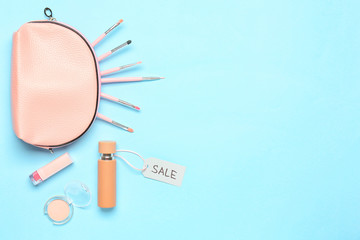 Bottle of perfume with makeup cosmetics and bag on color background