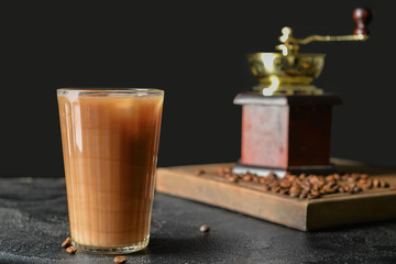 Glass of tasty iced coffee on dark background