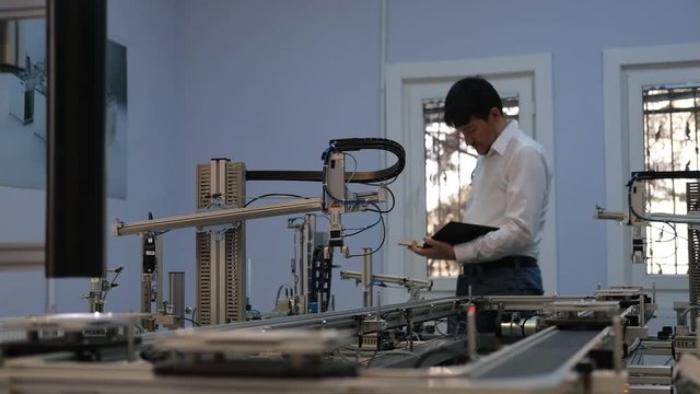 Industry 4.0 concept; Engineer is working at smart factory prototype. automated car on production line, artificial intelligence in smart manufacturing.