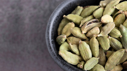 Cardamom seeds on concrete background. Aromatic herb and Spicy Seasoning for cooking concept.