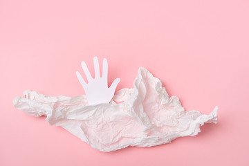 paper hand and crumpled paper on pink background. concept of care and kindness, charity, helping. copy space