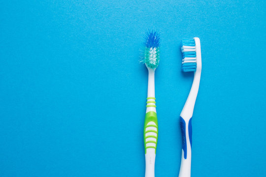 Used old and new toothbrush on a blue background.