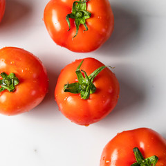 Fresh ripe tomatoes on light marble background. Summer organic vegetable for salad