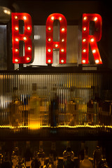 BAR sign with lights in the dark. with bottles of alcohol.  
