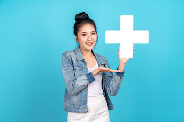 Happiness asian woman smiling, showing plus or add sign and other hand open on blue background....