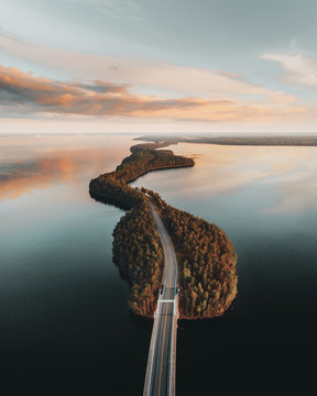 Aerial view of Pulkkilanharju bridge passing amidst sea during sunset