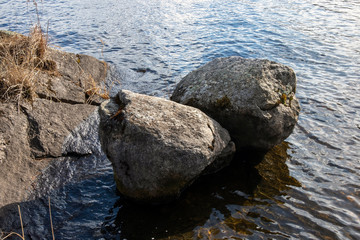 two boulders on a rocky lake shore