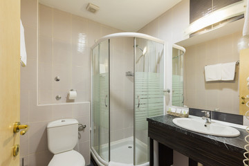 Interior of a hotel bathroom with glass shower cabin