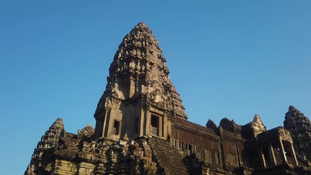 Slow moving shot of main Angkor wat temple tower with clear blue sky without tourists