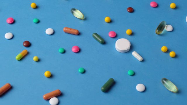 Background of pills, tablets, vitamins, drugs, omega 3 fish oil, gel capsules, medicament and food supplement for health care on blue  
