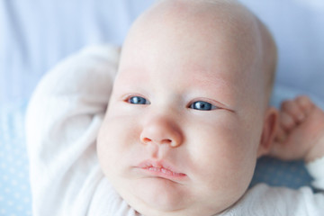 closeup baby in white overalls with white lace