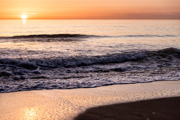 tramonto in riva al mare con onde sulla spiaggia