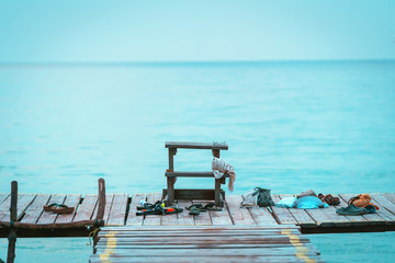 Diving equipment and clothing on a wooden bridge at sea with relax in sea concept