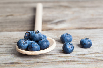 Bilberries on a wooden spoon. Concept for healthy nutrition. Rustic wooden background.