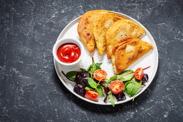 Latin American, mexican, chilean food. Traditional baked pastry empanadas with beef meat on stone background