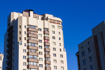 Obraz premium Multi-storey residential buildings in the city against the blue sky.