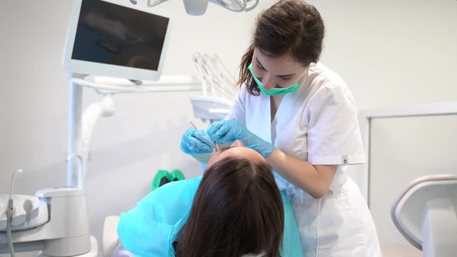Female denist examining teeth of a woman