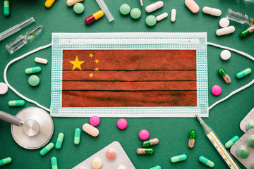 Covid19 virus in China, protective surgical Chinese flag mask and medicine background.