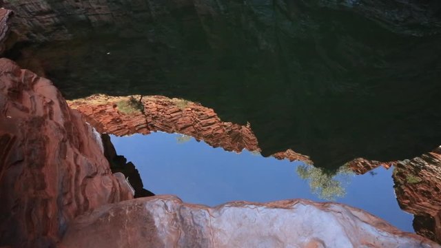 Beautiful footage of nature water pool on sandstone reflection between iron ore rocks formation gorge rock pool at Knox Gorge in Karijini National Park Western Australia