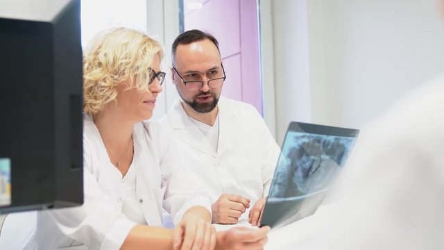 Dentists looking at x-ray image and discussing