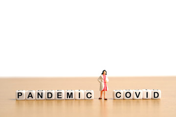 Pandemic corona virus conceptual miniature people photography &ndash; word beads alphabet covid with doctor figure