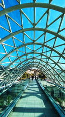 Fototapeta premium TBILISI, GEORGIA DECEMBER 14, 2019: Bridge of peace, glassed bridge above river in Tbilisi, Georgia