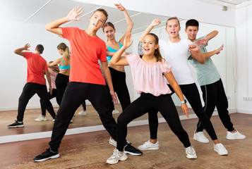 Fototapeta na wymiar Group portrait of glad teenagers in dance studio