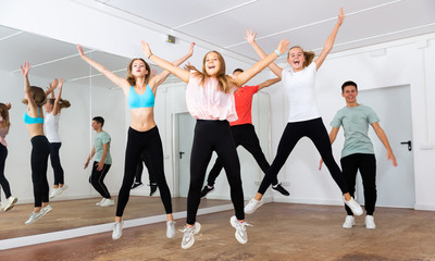 Fototapeta na wymiar Teenage boys and girls jumping in dance studio