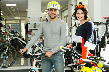 Fototapeta na wymiar man and woman in helmet standing with bike
