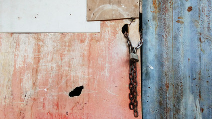 a locked wooden door with padlock and chain