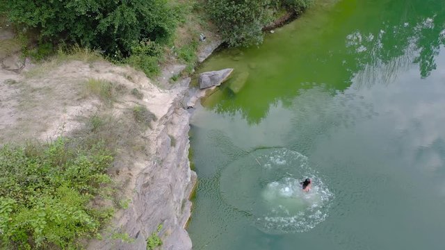 Young girl unsuccessfully jumps from the mountain into the water