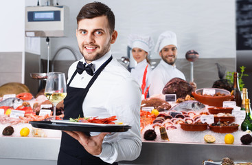 Waiter holding tray with seafood dishes at fish restaurant again