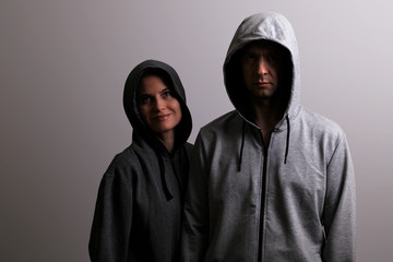 Man and woman in hoods stand by, low key