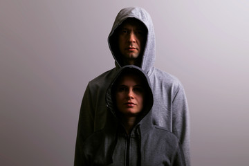 Man and woman in hoods stand by, low key