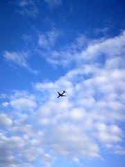Fototapeta na wymiar Flugzeug am blauen Himmel mit Wolken 