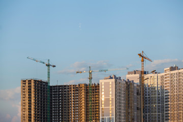 Fototapeta na wymiar Construction site with cranes against the blue sky 