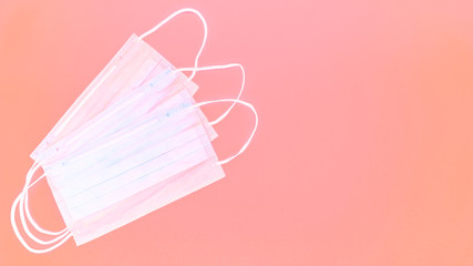 Medical mask on a pink background to prevent the spread of the virus, coronavirus, flu, colds, top view, copy space for your text.