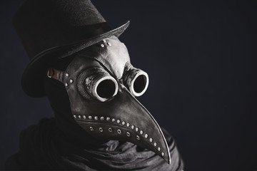 Masked man plague doctor, head profile, with bird mask and hat. Vintage style. Biohazard concept.