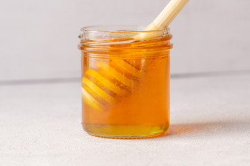 Honey jar, pot, wooden spoon inside. Close-up. healthcare, medicine. 