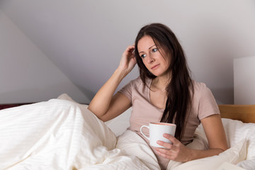 frau sitz nachdenklich im bett