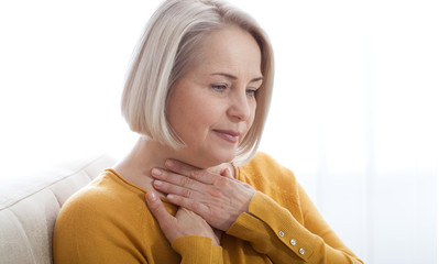Sore throat woman at home.