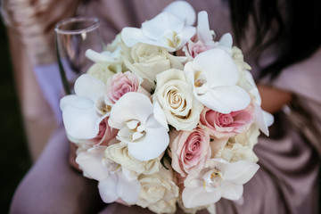 Beautiful bride is holding a wedding colorful bouquet. Beauty of colored flowers. 
