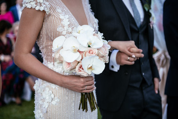 Beautiful bride is holding a wedding colorful bouquet. Beauty of colored flowers. 