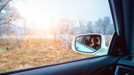 Car mirror with reflection of photographer on nature background.