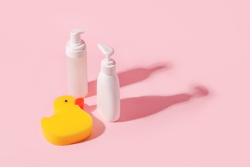 Spa and bath concept. Baby bath set. Cute child spa composition in yellow pink color. Soap bottle and washcloth duck. Copy space, minimal trendy idea, banner, flyer