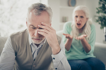 Close up photo of upset sad tired exhausted man touching head having headache from the voice of his aggressive wife