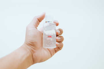 one man hand is carrying alcohol gel for washing hands to protect against covic 19 virus isolated on white background.