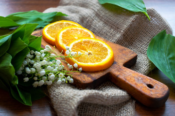 lilies and sliced orange on the sackcloth background © nutalina