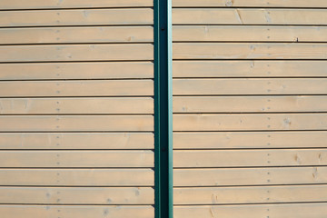 Wooden texture background with planks and green metal bar in sunlight