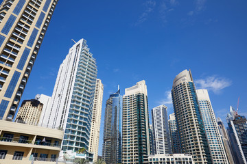 Fototapeta na wymiar Dubai Marina skyscrapers, low angle view in a sunny day, clear blue sky in Dubai